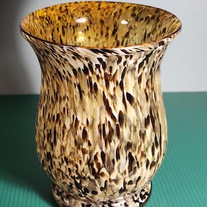 以下が含まれることがあります： 茶色、ベージュ、クリーム色の斑点模様の装飾ガラス花瓶。 花瓶はフレアトップと丸みを帯びたベースを備えています。 斑点模様は花瓶にユニークで質感のある外観を与えます。 花や装飾的なアクセントとして飾るのに適しています。