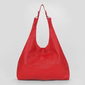 Oversized red leather hobo bag with a soft slouchy silhouette and bold minimalist design. Stylish genuine leather shoulder tote featuring a spacious large capacity interior, vibrant red color, pebbled leather texture, and adjustable shoulder straps. Chic statement handbag perfect for work, travel, shopping, and everyday fashion. Trendy oversized leather tote purse with modern quiet luxury aesthetic, designer inspired carryall bag, handmade shoulder handbag, laptop friendly work tote