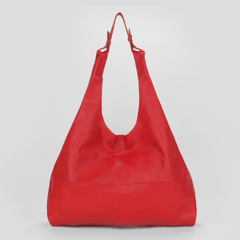 Oversized red leather hobo bag with a soft slouchy silhouette and bold minimalist design. Stylish genuine leather shoulder tote featuring a spacious large capacity interior, vibrant red color, pebbled leather texture, and adjustable shoulder straps. Chic statement handbag perfect for work, travel, shopping, and everyday fashion. Trendy oversized leather tote purse with modern quiet luxury aesthetic, designer inspired carryall bag, handmade shoulder handbag, laptop friendly work tote