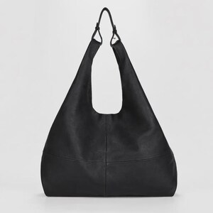 Oversized black leather hobo bag with a soft slouchy silhouette and minimalist modern design. Elegant genuine leather shoulder tote featuring a spacious large capacity interior, smooth pebbled texture, adjustable shoulder straps, and chic quiet luxury aesthetic. Stylish women’s everyday handbag perfect for work, travel, shopping, and daily essentials. Trendy oversized leather tote purse, designer inspired carryall bag, casual minimalist fashion accessory, laptop friendly shoulder bag
