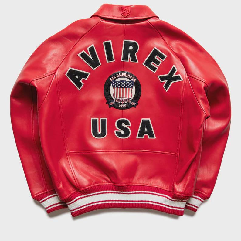 Close-up detail of premium red genuine leather texture on a men’s bomber jacket highlighting the smooth leather grain and high quality craftsmanship. The reinforced stitching and durable construction reflect authentic vintage leather outerwear design. This aviator style leather jacket combines retro fashion with modern streetwear trends, making it a stylish choice for fall winter outfits.