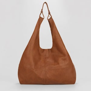 Oversized brown leather hobo bag with a soft slouchy silhouette and minimalist modern design. Stylish genuine leather shoulder tote featuring a spacious large capacity interior, rich vintage tan color, adjustable shoulder straps, and elegant quiet luxury aesthetic. Chic everyday handbag for women perfect for work, travel, shopping, and casual wear. Trendy oversized leather tote purse, designer inspired carryall bag, handmade leather shoulder bag, laptop friendly work tote, minimalist fashion
