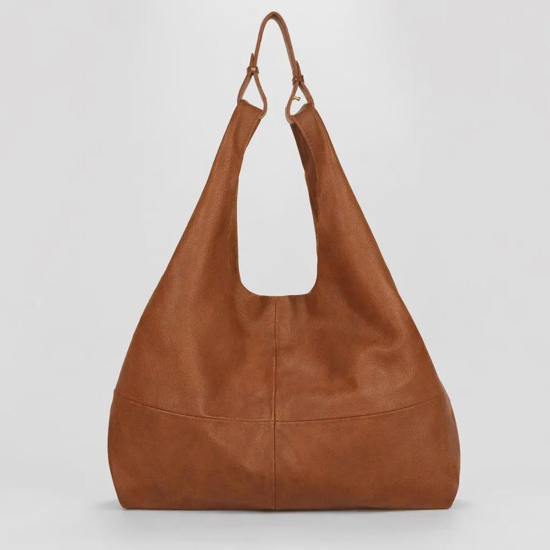 Oversized brown leather hobo bag with a soft slouchy silhouette and minimalist modern design. Stylish genuine leather shoulder tote featuring a spacious large capacity interior, rich vintage tan color, adjustable shoulder straps, and elegant quiet luxury aesthetic. Chic everyday handbag for women perfect for work, travel, shopping, and casual wear. Trendy oversized leather tote purse, designer inspired carryall bag, handmade leather shoulder bag, laptop friendly work tote, minimalist fashion