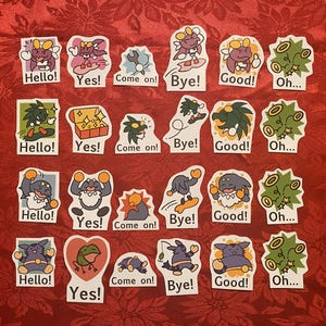 May include: A collection of colorful stickers with cartoon characters and various text phrases. The stickers feature phrases like "Hello!", "Yes!", "Come on!", "Bye!", "Good!", and "Oh...". The stickers are on a red background.