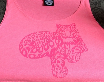 May include: Pink tank top with a pink graphic print of a snow leopard lying down. The tank top has a black tag with the word "CHAOS" printed on it.