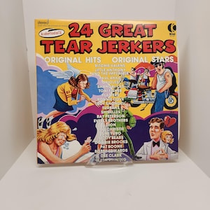 May include: A yellow vinyl record cover with the title "24 Great Tear Jerkers" and a list of original hits and original stars, including Ritchie Valens, Little Anthony and the Imperials, Paul Anka, and the Orioles. The cover features illustrations of people and a motorcycle.
