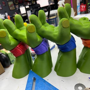 Könnte beinhalten: Ein Set aus drei Keramikbechern mit gesprenkelter, matter Oberfläche. Die Becher sind in Creme-, Hellgrau- und Dunkelgrautönen gehalten. Jeder Becher hat ein schlichtes, minimalistisches Design und einen abgerundeten Henkel.