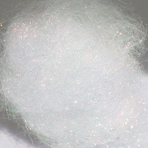 以下が含まれることがあります： 白い虹色のクラフトファイバーのクローズアップ。ファイバーは非常に細かく、わずかに輝いています。