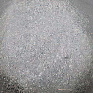 以下が含まれることがあります： 虹色の青と緑の繊維のボールのクローズアップ。繊維は非常に細かく、柔らかくふわふわした質感です。