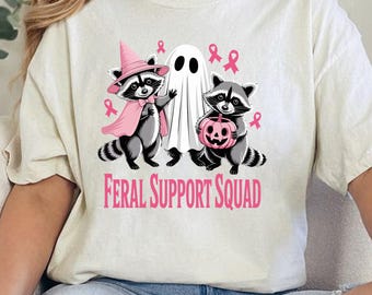 PNG de Escuadrón de Apoyo Salvaje: Mapaches de Halloween, diseño de sublimación con lazo rosa para concientizar sobre el cáncer de mama