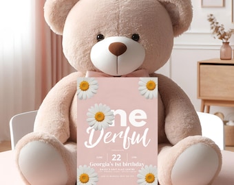 May include: A pink and white birthday invitation with a large white daisy and the text "One Derful" in white. The invitation is held by a large, light brown teddy bear. The text on the invitation reads "June 22 Georgia's 1st birthday Daisy's Soft Play Centre 123 Flower Lane, Birthdaytown Come in whatever you feel like wearing!"
