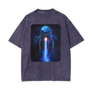Puede incluir: Una camiseta de color morado oscuro con un estampado gráfico de un pulpo azul y morado con una boca y tentáculos brillantes. El pulpo está rodeado de un fondo azul oscuro.
