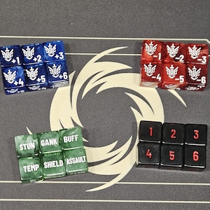 Può includere: Un set di dadi per giochi da tavolo. Include dadi blu con simboli e numeri bianchi, dadi rossi con numeri negativi bianchi, dadi verdi con testo e dadi neri con numeri rossi. I dadi sono disposti su una superficie grigia.