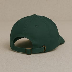 May include: A dark green baseball cap with a brown adjustable strap and buckle.