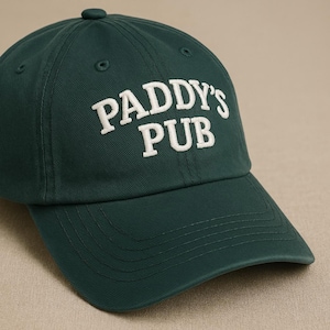 May include: A dark green baseball cap with white embroidered text that reads "PADDY'S PUB".