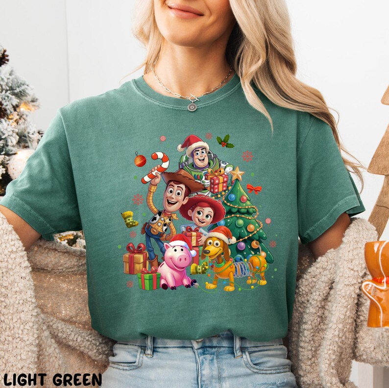 A woman wearing a green t-shirt with a Christmas-themed graphic featuring characters from the Toy Story movie.