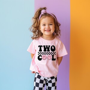 a little girl standing in front of a colorful wall