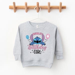 a gray sweatshirt with a cartoon character on it