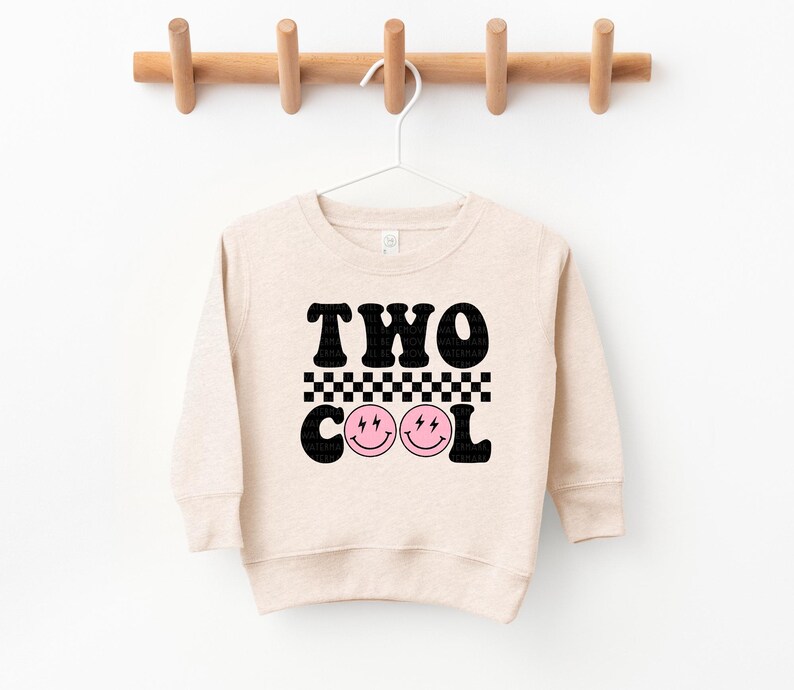a sweater hanging on a clothes rack with two cool faces on it