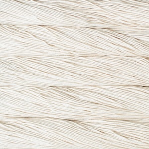 Puede incluir: Una vista de cerca de m&uacute;ltiples hebras de hilo de color blanco roto dispuestas en l&iacute;neas horizontales paralelas. La textura de las fibras retorcidas es claramente visible, mostrando los cabos individuales del hilo mientras recorren el marco.