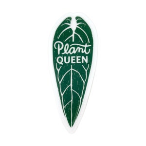 May include: A green leaf-shaped sticker with the words "Plant QUEEN" in white script. The sticker has a white border and a detailed leaf vein design. The sticker is a botanical-themed item.