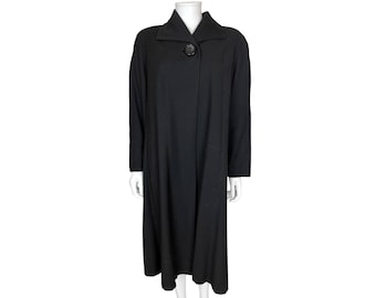 Può includere: Un lungo cappotto nero con una chiusura a bottone singolo sul collo.