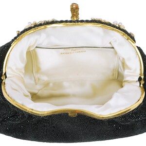 May include: Black beaded evening bag with a gold clasp and a white satin lining. The bag has a label that reads "Made in Canada, Eaton's".