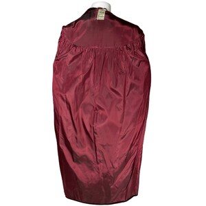 May include: A burgundy velvet jacket with a green label on the back.