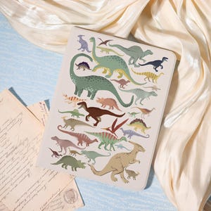 Könnte beinhalten: Eine rechteckige Tablet-Hülle mit einer farbenfrohen Illustration verschiedener Dinosaurier in Grün-, Braun- und Rosatönen. Das Design umfasst eine Vielzahl von Dinosaurierarten und schafft ein spielerisches und lehrreiches Thema. Die Hülle befindet sich vor einem cremefarbenen Hintergrund.