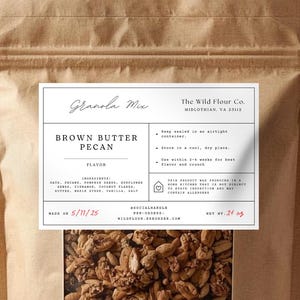 以下が含まれることがあります： 「Brown Butter Pecan」とラベルされた、透明な窓が付いた茶色の紙袋に入ったグラノーラミックス。 ラベルには材料と「賞味期限」の日付が含まれています。 袋には28グラムのグラノーラが入っています。
