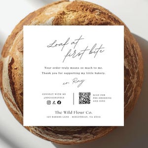 May include: A loaf of bread with a white card on top. The card reads "Loaf at first bite" and includes text about supporting a bakery. The bread has a golden-brown crust.
