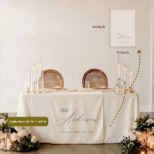 May include: A wedding table setting with a cream tablecloth and runner. The runner is personalized with "The Andersons" and the wedding date. The table is 200cm wide and 76cm high. Includes a sign that is 25cm x 152cm.