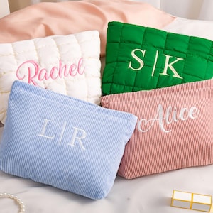 Peut inclure: Quatre trousses de maquillage personnalis&eacute;es de couleurs vari&eacute;es : blanc, vert, bleu et rose. Le sac blanc est matelass&eacute; et brod&eacute; avec "Rachel". Le sac vert porte "S|K". Le sac bleu porte "L|R". Le sac rose porte "Alice".