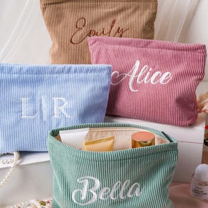 Puede incluir: Cuatro estuches de pana en color beige, rosa, azul claro y verde salvia. El estuche beige lleva bordado el nombre Emily, el rosa Alice y el verde salvia Bella. El estuche azul claro muestra las iniciales bordadas LR.