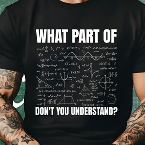 May include: A black short-sleeved t-shirt featuring the white text "WHAT PART OF" at the top and "DON'T YOU UNDERSTAND?" at the bottom, with various mathematical formulas, geometric shapes, and algebraic equations printed in white in the center.