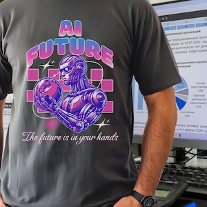 Puede incluir: Camiseta gris oscuro con un gráfico de un robot sosteniendo un globo, con las palabras "AI FUTURE" arriba y "The future is in your hands" abajo. El robot y el texto son en tonos morados, rosas y azules.