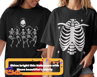 Puede incluir: Dos camisetas negras con estampados gráficos en blanco. La camiseta de la izquierda muestra cinco esqueletos bailando y una calavera. La camiseta de la derecha presenta una gran ilustración de una caja torácica blanca con estrellas. El texto en la superposición dice: Shine bright this Halloween with these beautiful t-shirts.