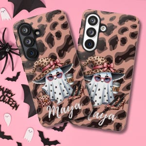 Puede incluir: Dos fundas para teléfono con diseño de estampado de leopardo. Cada funda presenta un fantasma de dibujos animados con gafas de sol, un sombrero y sosteniendo una taza de café. El nombre "Maya" está escrito en cursiva. Las fundas están decoradas con tacones altos y un bolso.