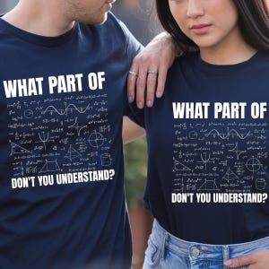 Puede incluir: Dos camisetas azul marino con el texto blanco "WHAT PART OF DON'T YOU UNDERSTAND?" y ecuaciones matemáticas. Las camisetas son usadas por dos personas.