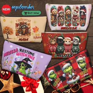 Puede incluir: Cinco neceseres con cremallera que presentan varios diseños festivos y estacionales. Uno muestra un mapache con hojas de otoño, otro cinco perros con gorros de Papá Noel, un tercero cuatro gatitos con jerséis, uno una bruja y otro un personaje verde sobre cuadros rojos.