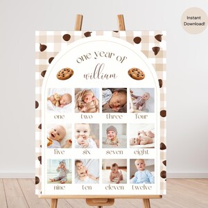 Peut inclure: Un chevalet en bois présente une affiche des étapes de la première année d'un bébé. L'affiche présente une grille de douze photos, chacune représentant un mois. La conception comprend le texte "one year of william" et des illustrations de biscuits.
