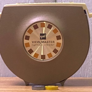 Könnte beinhalten: Eine weiße Keramik-Tasse mit schwarzem Henkel und dem Text "But First, Coffee" in handschriftlichem Stil. Die Tasse steht auf einer weißen Oberfläche. Die Tasse ist etwa 10 cm hoch.