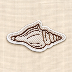 Puede incluir: Un parche bordado con forma de concha marina. La concha presenta un patrón de rayas diagonales en color beige claro y blanco con contornos bordados en marrón oscuro y un borde grueso cosido en blanco que rodea toda la forma de la concha.