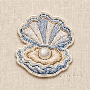 May include: Embroidered seashell patch featuring a pearl. The patch has a light blue, white, and tan color scheme with a wavy border. The design includes a detailed depiction of an open clam shell with a pearl inside.