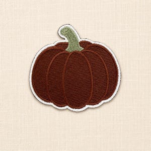 Peut inclure: Un écusson brodé en forme de citrouille. La citrouille est marron foncé avec une tige vert clair et est entourée d'une épaisse bordure blanche. La broderie crée une surface texturée avec des lignes verticales visibles définissant la forme.