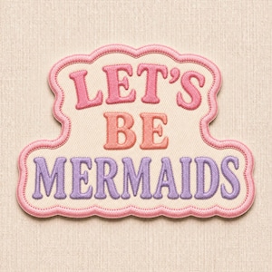Puede incluir: Un parche bordado con fondo color crema y borde festoneado rosa. El texto dice LET'S BE MERMAIDS, con LET'S en rosa, BE en coral y MERMAIDS en morado, todo ello con un diseño de puntadas en relieve y con textura.