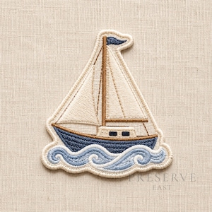 May include: An embroidered patch featuring a sailboat with a dark blue hull, cream-colored sails, and a brown mast. The boat sits atop stylized light blue waves. The entire design is outlined in a cream-colored border on a textured fabric.