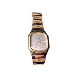 May include: A vintage wristwatch with a silver face, gold-tone bezel, and a two-tone gold and silver band. The watch face displays the day and date. The band is approximately 7.5 inches long.