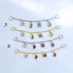 May include: Four delicate jewelry connectors featuring small metal chains with four dangling gemstones each. Two are silver-toned and two are gold-toned. The stones include round, marquise, square, and pear shapes in various colors. Labeled A and B.