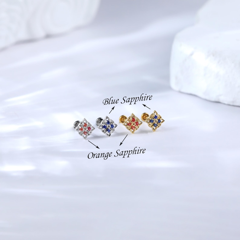 May include: Three different colored square-shaped earrings with a small stud post. The earrings are labeled "Blue Sapphire" and "Orange Sapphire".